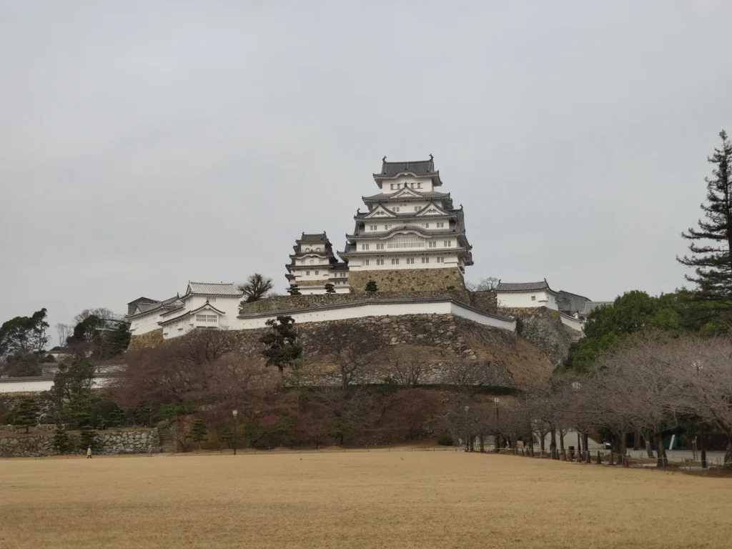 Les donjons blancs du château de Himeji et leurs toitures au-dessus des soubassements de pierre.